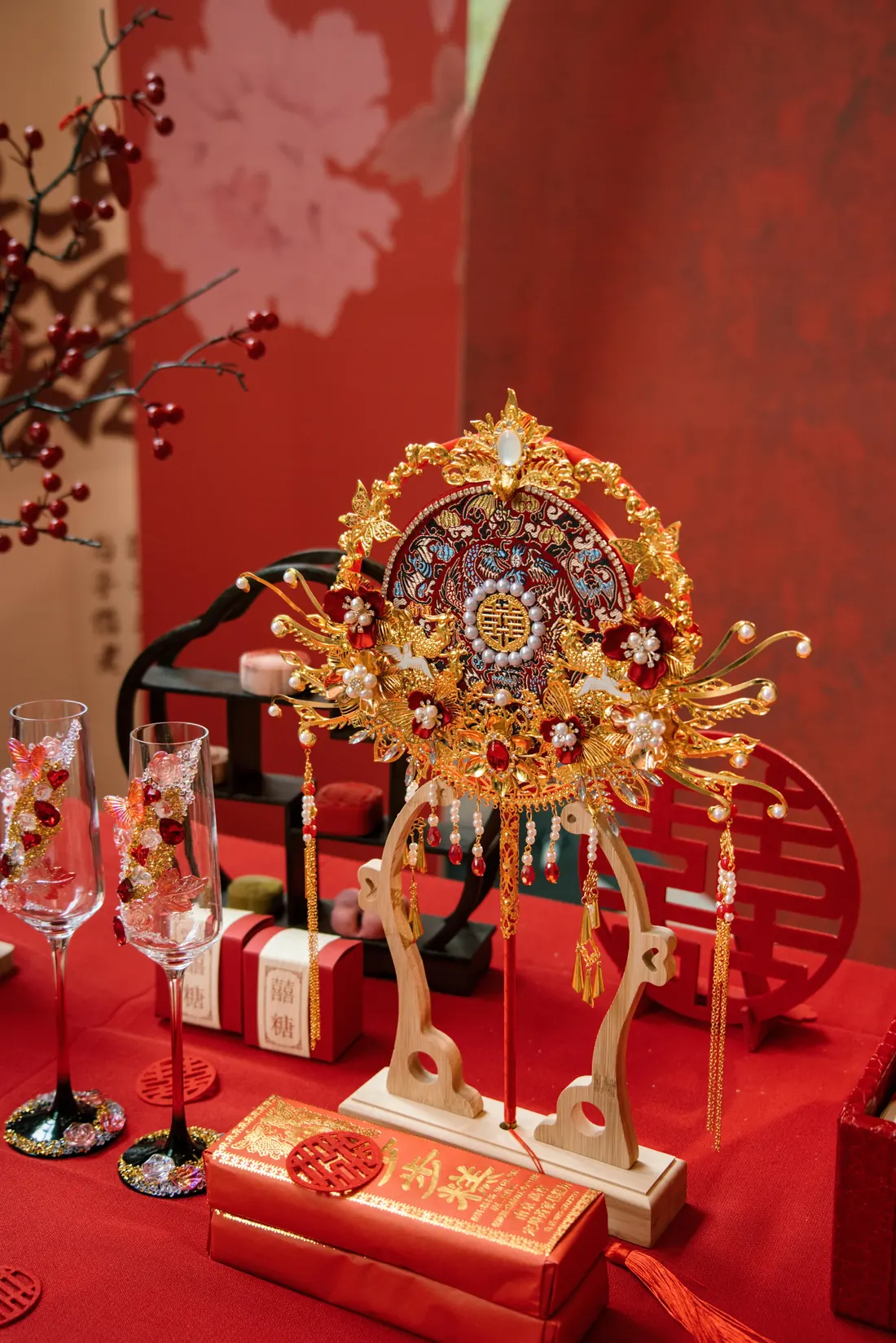 A red and gold Chinese wedding table with a phoenix crown and red gift boxes