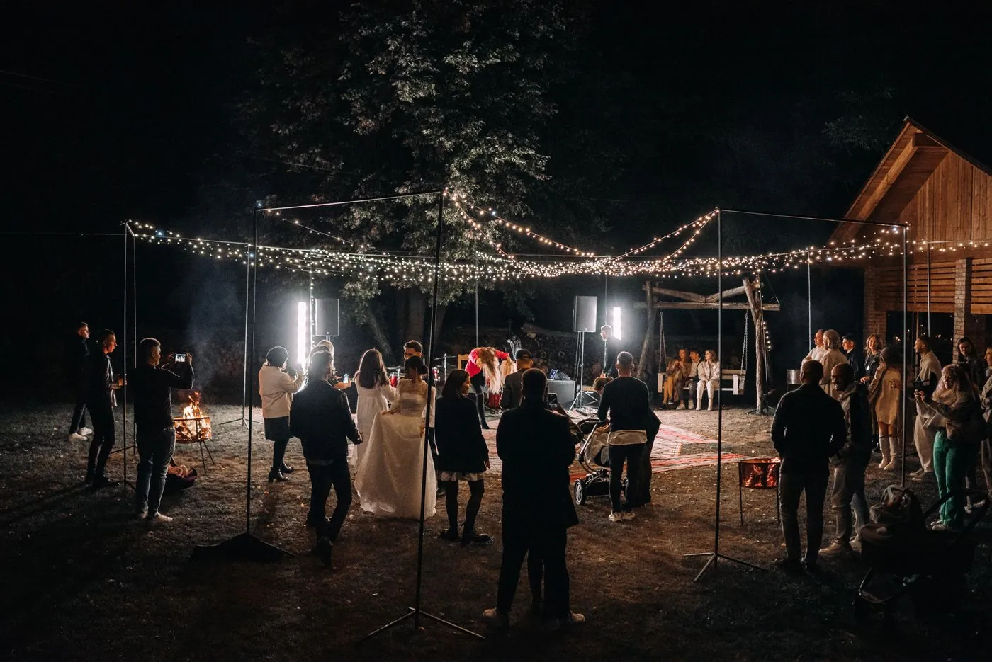 Guests at an evening reception under string lights
